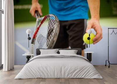 Close-up of male hand holding tennis ball and racket, professional tennis player starting set in the tennis hall Wall mural