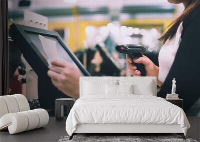 Young woman hands scaning / entering discount / sale on a receipt, touchscreen cash register, market / shop (color toned image) Wall mural