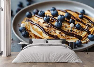 Crepes, thin pancakes with chocolate sauce and fresh blueberries. Grey background. Close up. Wall mural