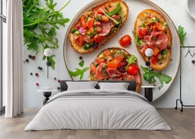 Set of bruschetta with jamon or prosciutto, vegetables and fresh arugula leaves on the plate on light marble background top view. Healthy homemade breakfast or lunch idea.  Wall mural