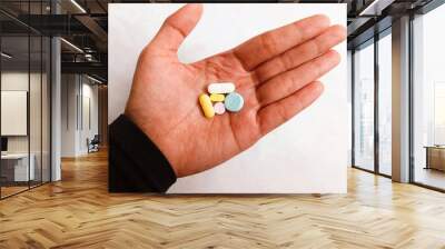 hand with pills. various types of medicine in hand. a hand holding various medicine isolated on white background. Wall mural