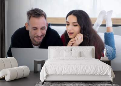 Portrait of couple using laptop on the bed Wall mural