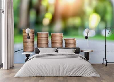 Coin Stacks Decreasing On Wooden Surface With Blurry Green Background Wall mural