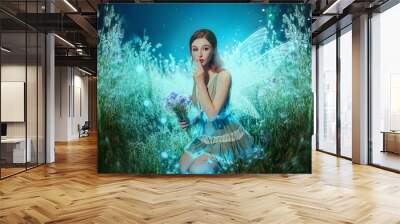 Art photo fantasy pixie butterfly. young fairy with glow wings holds bouquet flower. dark blue backdrop fabolous night Firefly star glitter light. Fingers show sign silence. cute face, makeup red lips Wall mural