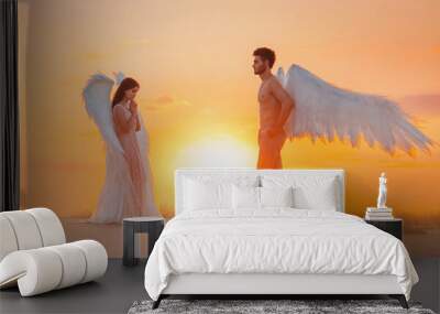 artistic processing. Two divine angels man and woman go to meet each other. design white costume wings. Girl with loose long hair brunette. Backdrop bright sunny sunset in fabulous natural sand desert Wall mural