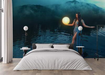 Fantasy woman holding moon magic light glowing planet in hand. Sexy Girl goddess night elf beauty face blacl long hair, river nymph wet blue dress, stands on water dark sky clouds lake. Lady fairy art Wall mural