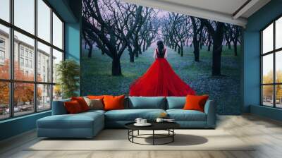 woman princess walk enjoy autumn forest nature back view. Lady Witch queen brunette wavy hair. Red vintage luxury tulle fluffy magnificent dress long train. spring park garden black bare tree trunks Wall mural