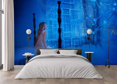 Young sleeping beauty woman sees sleep sits on medieval bed. Girl enchanted princess, enjoy Christmas miracle magic bedroom. Backdrop bright shining stars magic tree interior night room white art snow Wall mural