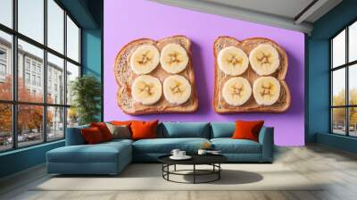 Two slices of whole grain toast with peanut butter and banana on a purple background Wall mural