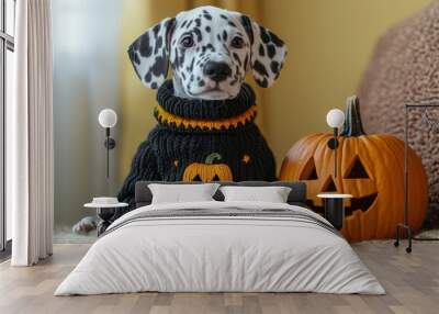 Halloween puppy. A Dalmatian puppy wearing a black knitted sweater with a jack o lantern pumpkin on it, sitting next to an orange pumpkin with carved jack-o'-lantern   Wall mural