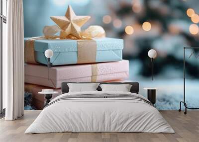 pastel colored Christmas gifts stacked on top of each other, tied with a gold ribbon and topped with a star, against a blurred background of tree lights and bokeh Wall mural