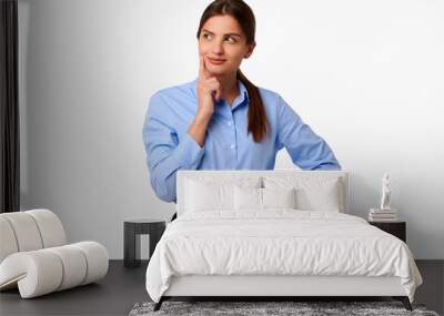 Pensive businesswoman in blue shirt on white isolated background Wall mural