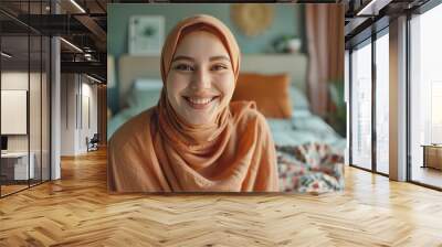 Close up view of the face of a Muslim woman wearing a hijab making a video call in the bedroom. Wall mural