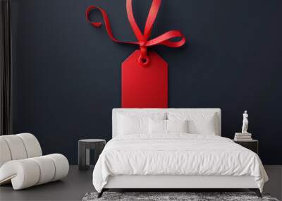 Vivid red sale tag hanging by a ribbon isolated on a dark grey background, suggesting a discount. Wall mural