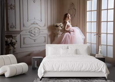 beautiful young blond woman in luxurious long pink dress posing in vintage room interior. indoor stu Wall mural