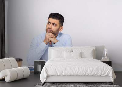 Hmm, need to think! Pensive thoughtful businessman sitting office workplace with laptop on desk, pondering business plan, having doubts, not sure. indoor studio shot isolated on white background Wall mural