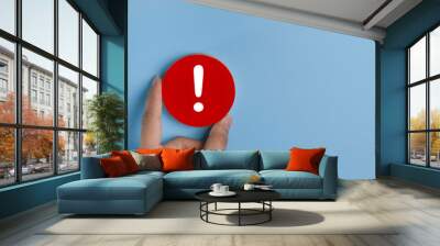 Attention caution warning concept. Hand holding red page with exclamation error mark for important alert signal, Hazard, risk ,danger background with copyspace. Wall mural