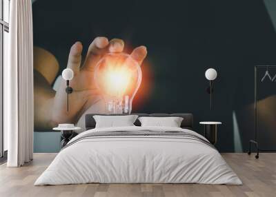 Businessman holding light bulb Creativity and innovation success.Concept of new idea with energy and power Wall mural