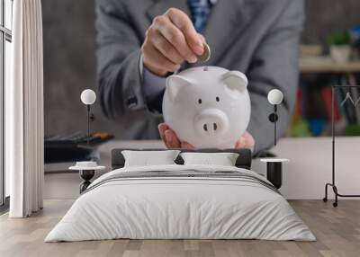 businessman holds a piggy bank as a concept of saving money for investment. Business related to taxes, money, finance, banking. Wall mural