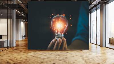 hand hold light bulb on black background.Inspiration and Creativity Concepts. Wall mural