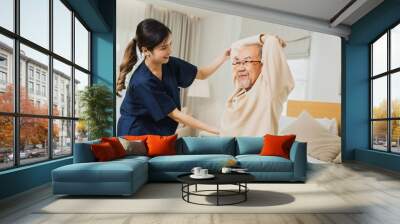 Asian nurse woman assisting old man warming up exercises for the upper body inside the nursing home, use walker with strong health and Help and care concept Wall mural