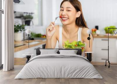 Close up Happy Asian healthy woman smiled and holding  vegetable salad and eat small tomato to diet and eat clean food Wall mural