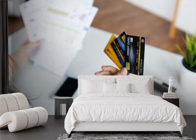 close up woman's hand holding three credit cards, feeling stressed about tax and debt problem from shopping online. Wall mural