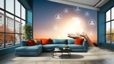 global social network and connection internet on abstract data worldwide cyberspace concept, close up hand holding wireless networking earth connect with people by 5G technology line online on sunset Wall mural