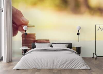 hand put money on pile of coins- concept in save and investment in business Wall mural