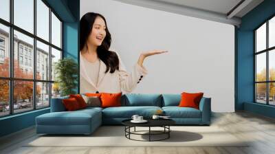 Happy and smiled business woman show empty hand to present product, attractive Asian beautiful girl with suit on white background Wall mural