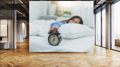 Woman's hand touch alarm clock on bed, lazy and rest time on holiday concept Wall mural