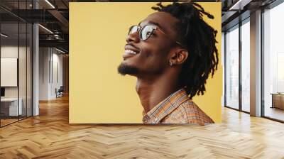 Smiling cool stylish Gen Z Black hipster guy looking away at copy space for advertising promotion against a vibrant yellow background, showcasing confidence and positivity. Wall mural