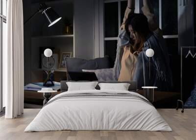 Asian businesswoman or freelancer working hard at the night looking the laptop digital tablet and document in workplace at late overtime deadline, Stressed busy and exhausted of work at home. Wall mural