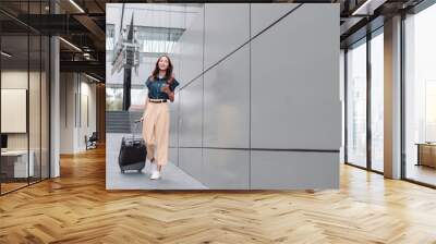 Beautiful asian female businesswoman use smartphone, Walk enjoy smiling while doing commuting in the modern city near office building outside Wall mural