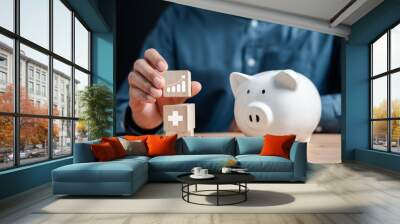 Businessman saving money in piggy bank to invest in life insurance and savings insurance. for the safety and growth of money in the future. Wall mural