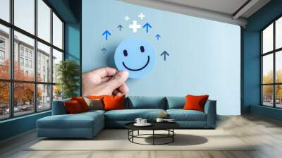 Hands holding blue happy smile face. mental health positive thinking and growth mindset, mental health care recovery to happiness emotion... Wall mural