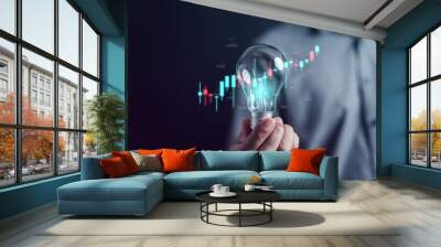 Man hand holding lightbulb start new idea for trading in stock market exchange investment growth and business strategy. Wall mural