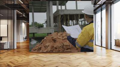 Professional architect engineer with hard hat and blueprint at building construction site house building permit background. Architects looking at blueprints. Construction and engineering industry Wall mural