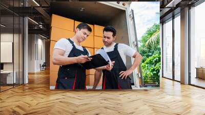 Unloading boxes and furniture from a pickup truck to a new house with service cargo two men movers worker in uniform lifting boxes. concept of Home moving and delivery. Wall mural