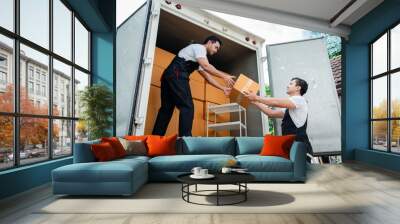 Unloading boxes and furniture from a pickup truck to a new house with service cargo two men movers worker in uniform lifting boxes. concept of Home moving and delivery. Wall mural