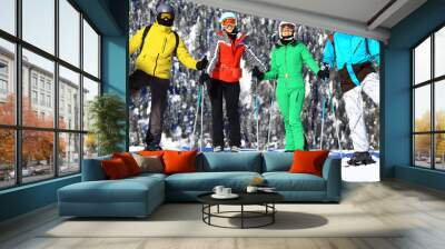 group of four friends at a ski resort posing on a slope in winter Wall mural