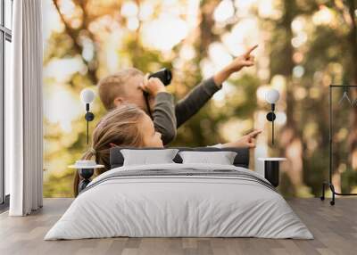 Children in the forest looking through binoculars exploring nature and wildlife	 Wall mural