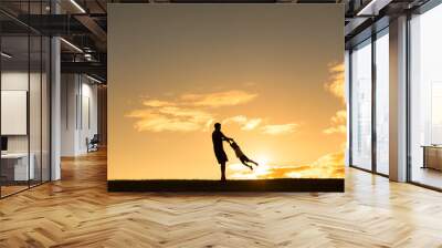 Father and child silhouette playing in the sunset  Wall mural