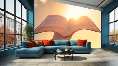 Hand holding bible up to the light  Wall mural