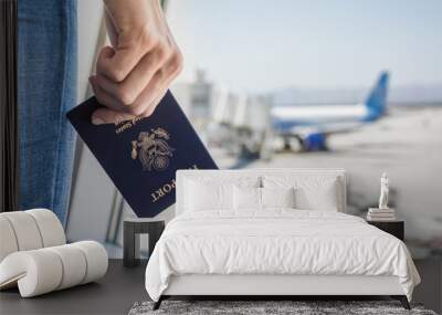 Hand holding USA passport at airport.  Wall mural