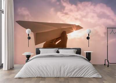 Hand throwing paper airplane. Flying high in the sky. Freedom, travel concept.  Wall mural