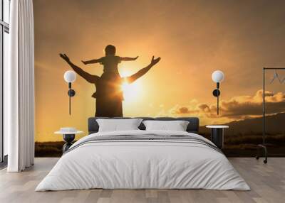 Happy father and son adventure outdoors in nature feeling free with arms in the air facing the sunset.  Wall mural