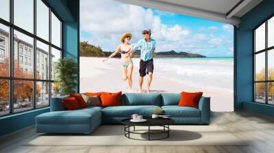 happy young couple running on white sand beach in Hawaii.  Wall mural