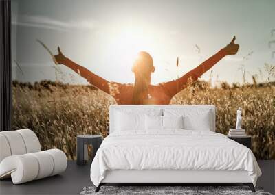 Having a positive mindset, wellbeing and hope concept. Happy young woman in a nature sunrise field with arms outstretched.	thumbs up Wall mural