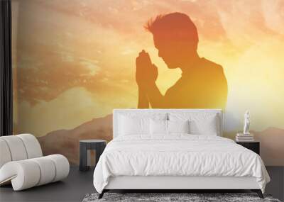 Man praying worshiping in the sunlight  Wall mural